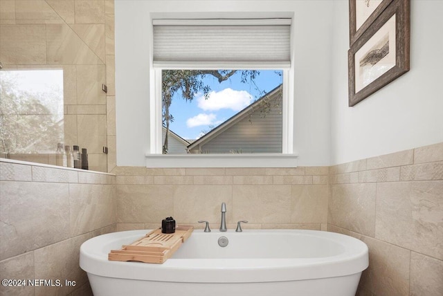 bathroom featuring tile walls and a bathing tub