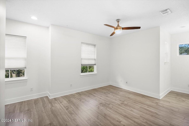 unfurnished room with light hardwood / wood-style floors, a textured ceiling, and ceiling fan