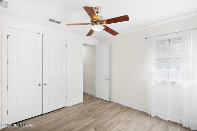 unfurnished bedroom featuring light hardwood / wood-style flooring, a closet, and ceiling fan