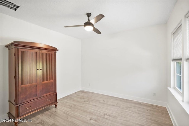 unfurnished bedroom featuring light hardwood / wood-style floors, a textured ceiling, and ceiling fan