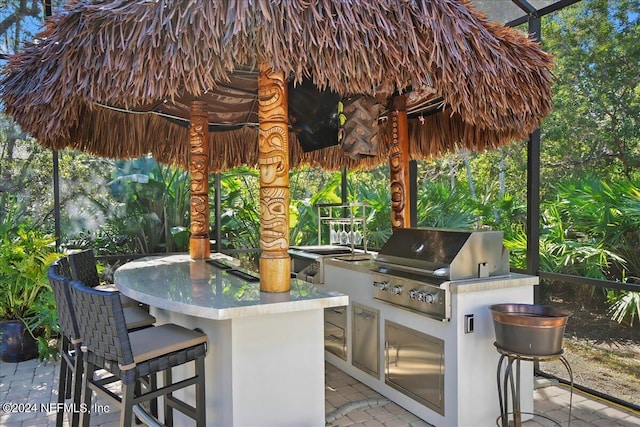 view of patio / terrace featuring a grill, exterior bar, and exterior kitchen