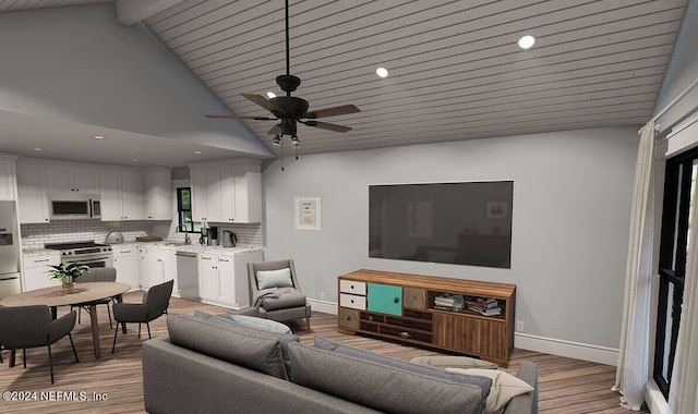 living room featuring light wood-type flooring, ceiling fan, beamed ceiling, and sink