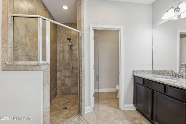 bathroom with vanity, tile patterned floors, an enclosed shower, and toilet