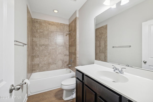 full bathroom with wood-type flooring, tiled shower / bath combo, vanity, and toilet