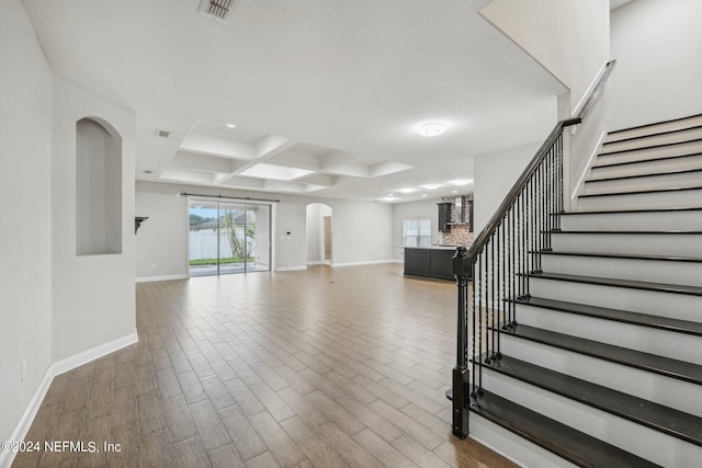 unfurnished living room with coffered ceiling and hardwood / wood-style flooring