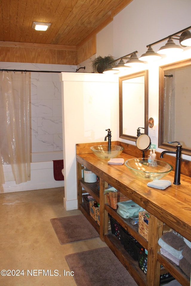 bathroom featuring shower / bathtub combination with curtain, wood ceiling, concrete flooring, and vanity