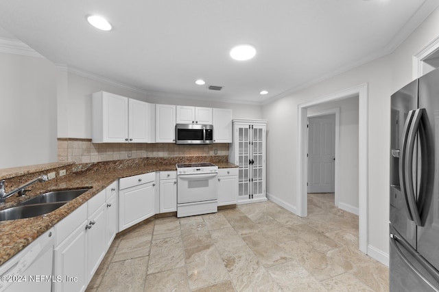 kitchen with tasteful backsplash, sink, white cabinets, appliances with stainless steel finishes, and dark stone countertops