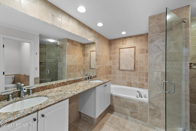 bathroom with tile walls, independent shower and bath, and vanity