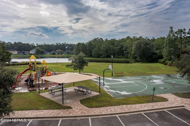 view of sport court featuring a water view, a yard, and a playground