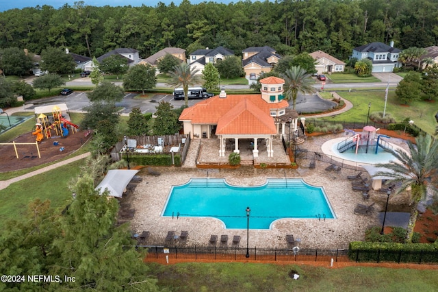 view of swimming pool featuring a playground and a patio area