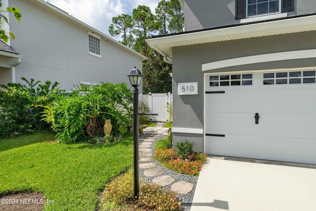 exterior space with a garage and a lawn