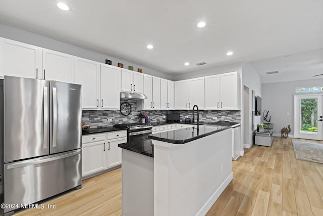 kitchen featuring white cabinetry, appliances with stainless steel finishes, light hardwood / wood-style flooring, and dark stone counters