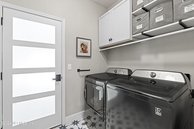 laundry area with cabinets and washing machine and clothes dryer