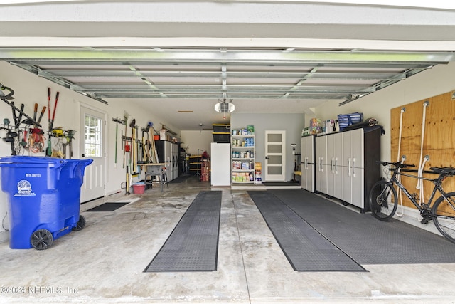 garage with a garage door opener and white refrigerator