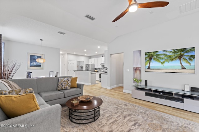 living room with lofted ceiling, ceiling fan, and light hardwood / wood-style flooring