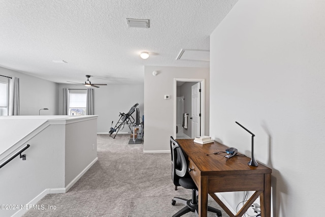 carpeted home office with a textured ceiling