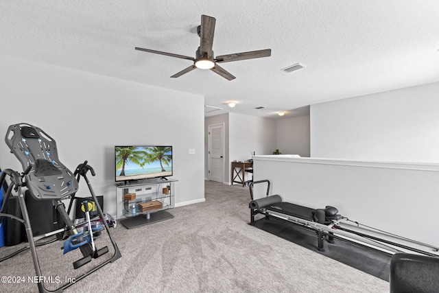 workout room with ceiling fan, carpet floors, and a textured ceiling