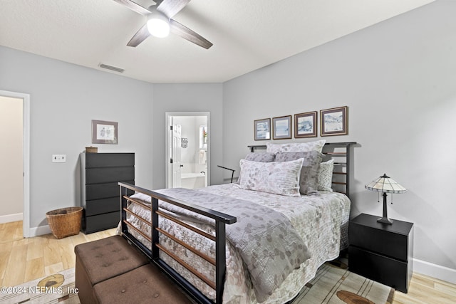 bedroom featuring hardwood / wood-style flooring, ceiling fan, ensuite bath, and a textured ceiling