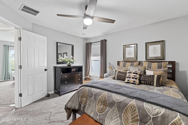 bedroom featuring ceiling fan, carpet, and a textured ceiling