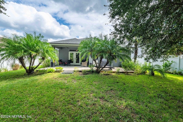 view of yard featuring a patio area, ceiling fan, and french doors