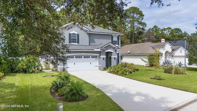 view of front of property featuring a garage and a front lawn