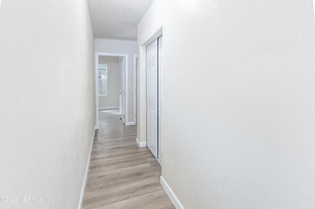 corridor with light hardwood / wood-style floors