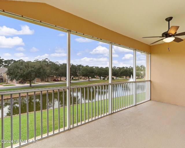 unfurnished sunroom featuring ceiling fan, a water view, and lofted ceiling