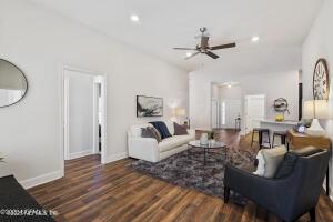 living room featuring lofted ceiling, dark wood-type flooring, and ceiling fan