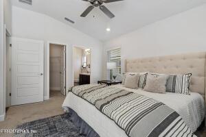 carpeted bedroom featuring ceiling fan and vaulted ceiling