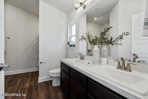 bathroom featuring vanity, hardwood / wood-style flooring, and toilet