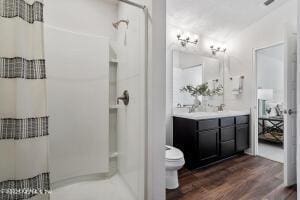 bathroom featuring vanity, toilet, hardwood / wood-style floors, and a shower