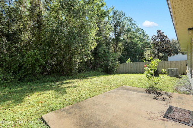 view of yard with central air condition unit and a patio