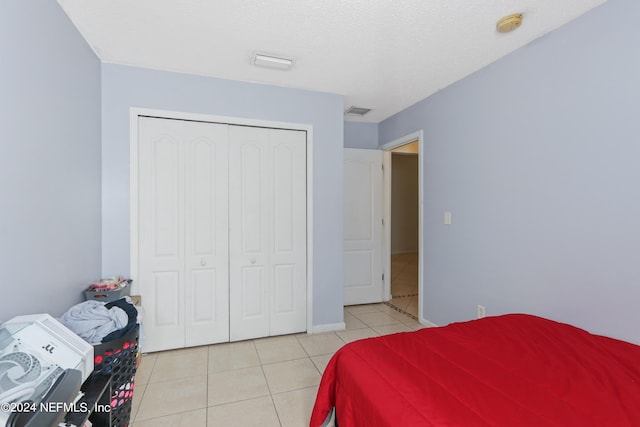 bedroom with light tile patterned floors and a closet