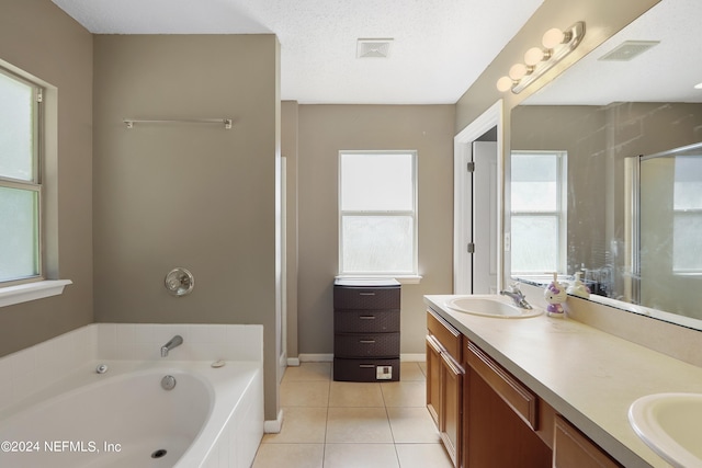 bathroom with plenty of natural light, vanity, a textured ceiling, and tile patterned flooring