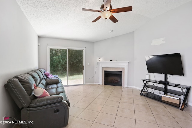 tiled living room featuring a textured ceiling, ceiling fan, and a tiled fireplace