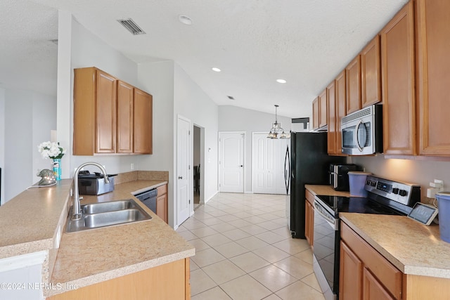 kitchen with appliances with stainless steel finishes, a textured ceiling, vaulted ceiling, sink, and decorative light fixtures