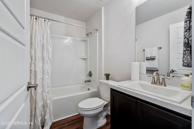 full bathroom featuring vanity, a textured ceiling, wood-type flooring, shower / tub combo with curtain, and toilet