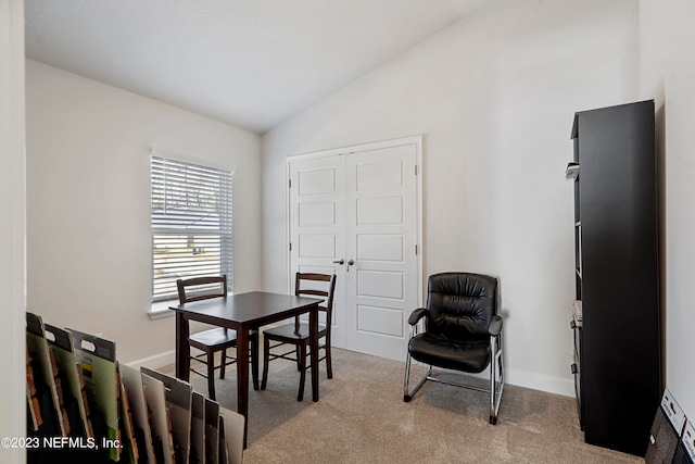 dining room featuring lofted ceiling and light colored carpet