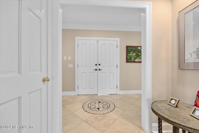 tiled foyer entrance featuring ornamental molding