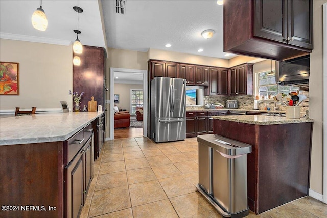 kitchen with stainless steel fridge, crown molding, a wealth of natural light, and hanging light fixtures