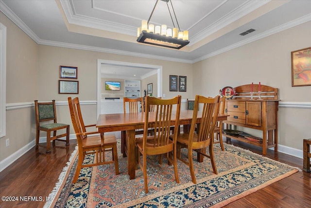 dining space featuring ornamental molding, a raised ceiling, a chandelier, and dark hardwood / wood-style flooring