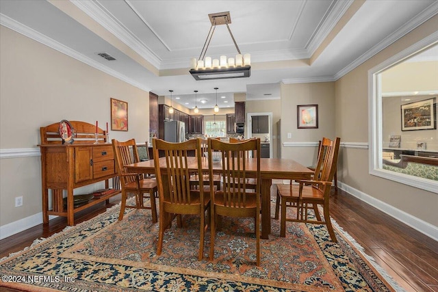 dining room with a raised ceiling, dark hardwood / wood-style flooring, and a wealth of natural light