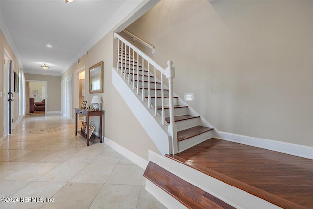 staircase with crown molding and hardwood / wood-style floors