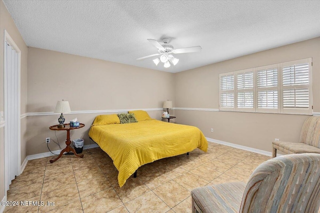 tiled bedroom featuring a textured ceiling and ceiling fan