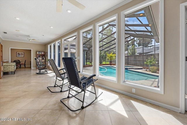 sunroom / solarium featuring a healthy amount of sunlight and ceiling fan