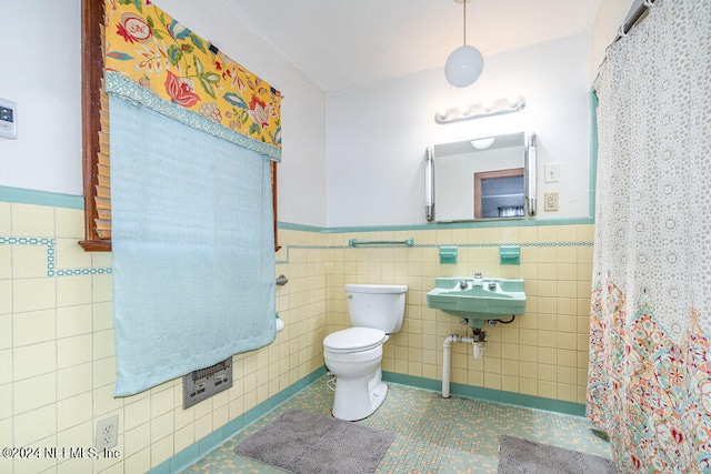 bathroom featuring sink, toilet, tile patterned flooring, and tile walls