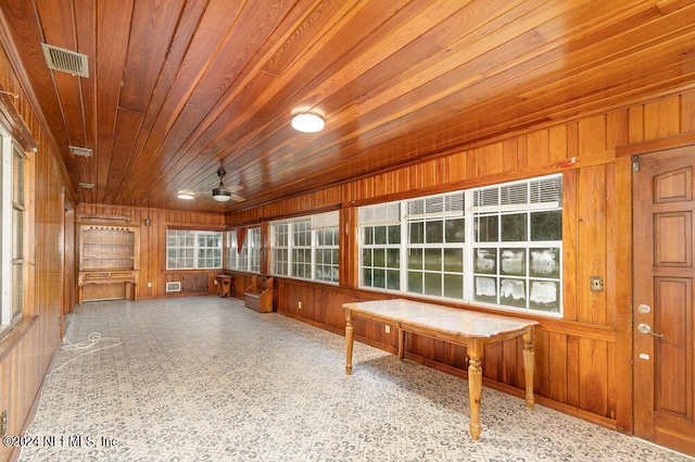 unfurnished sunroom featuring wood ceiling and ceiling fan