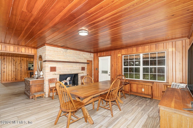 dining area with wood walls, wood ceiling, and light wood-type flooring