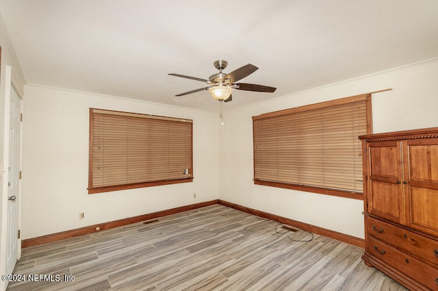 unfurnished bedroom featuring ornamental molding, light wood-type flooring, and ceiling fan