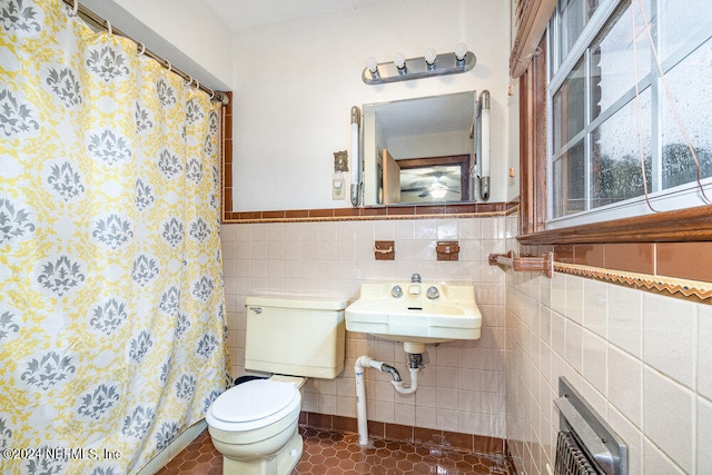 bathroom with tile patterned flooring, toilet, sink, tile walls, and a shower with shower curtain